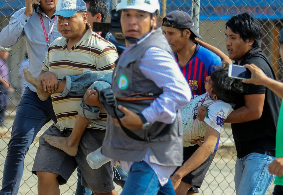 Manifestantes carregam ferido em protestos nas ruas de La Paz