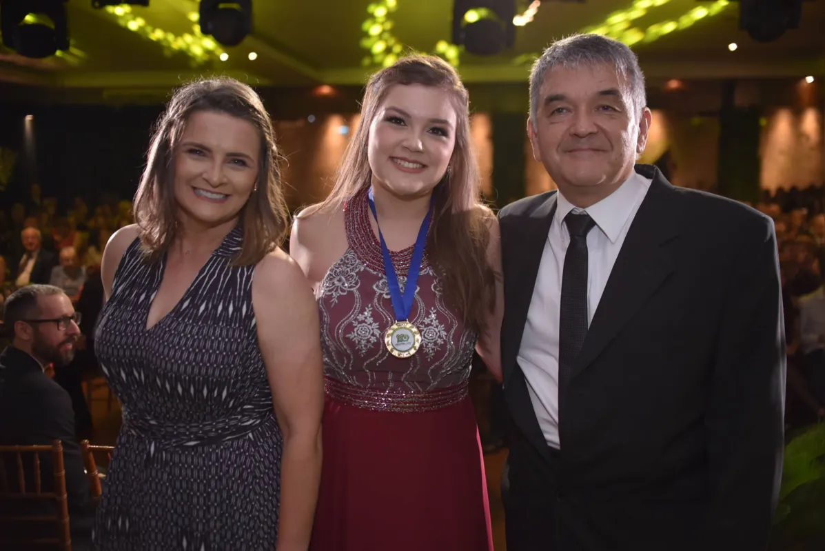 Olivia Krawulski Hiroki, formanda dona da melhor média do Terceirão do Universitário, ladeada pelos pais Cristina e Paulo