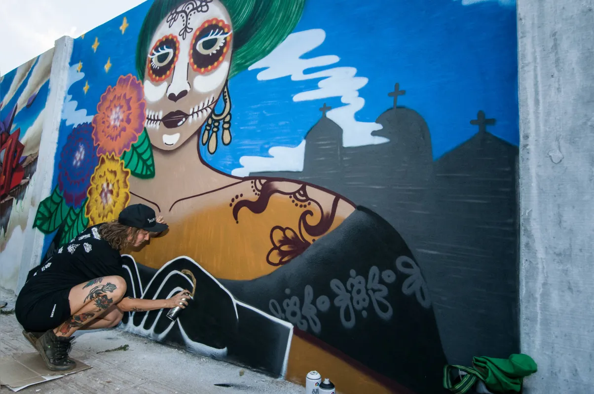 A gaúcha Dâmaris da Rosa, radicada no Peru, grafitou o muro do cemitério com elementos da 'festa dos mortos', do México 