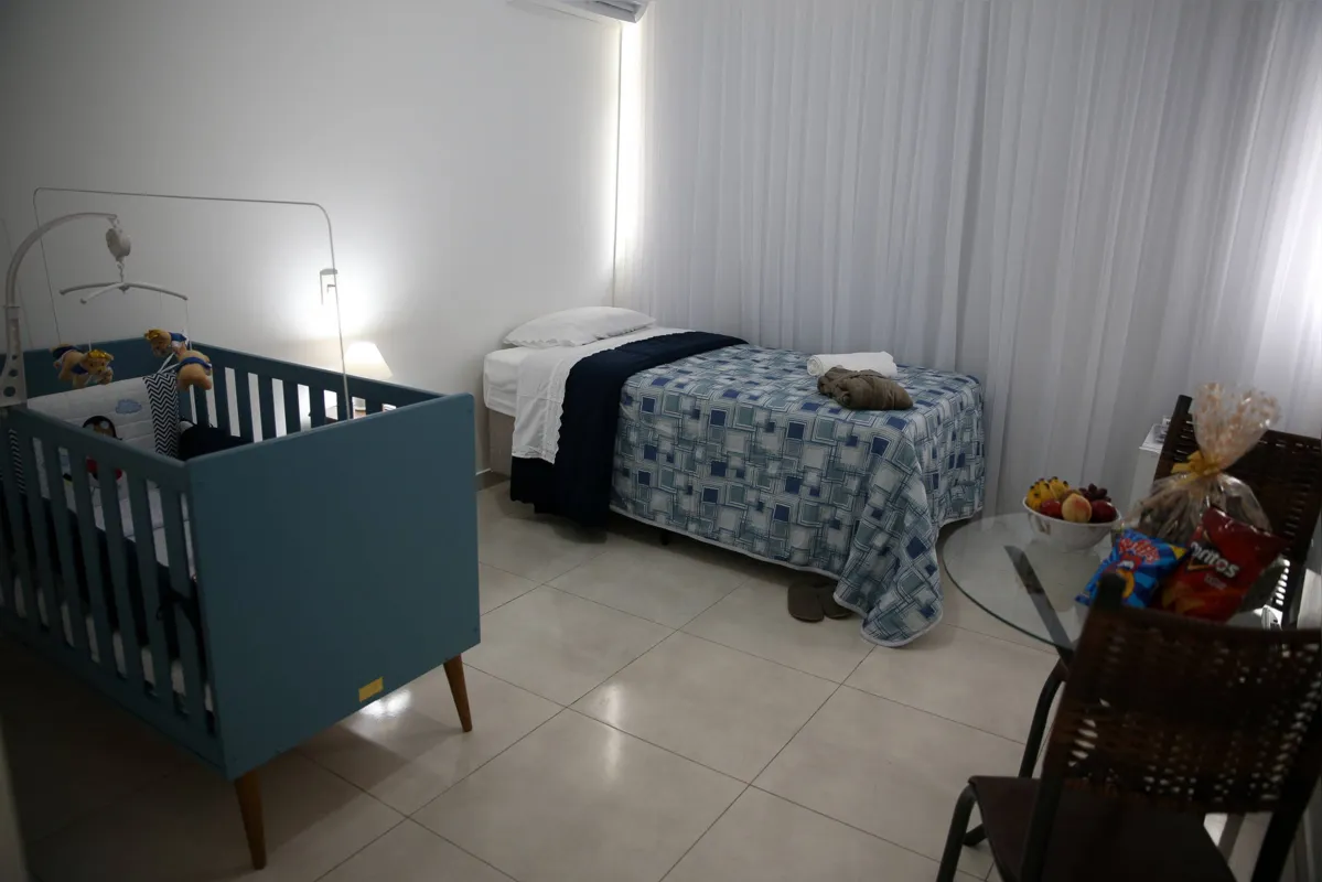 Cada quarto tem guarda-roupa, TV, ar-condicionado e mesa com uma cesta de frutas e doces 