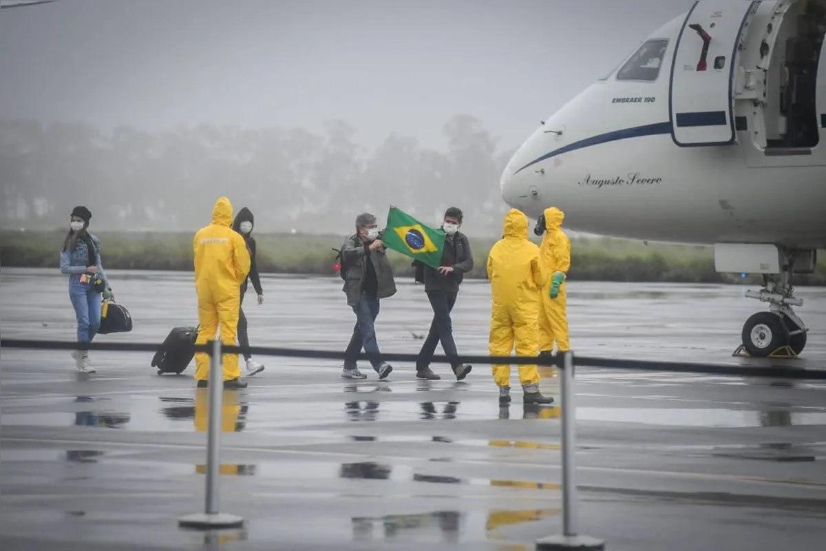No desembarque, membros de uma equipe militar esperavam com roupas impermeáveis, luvas e máscara para fazer a desinfecção da aeronave