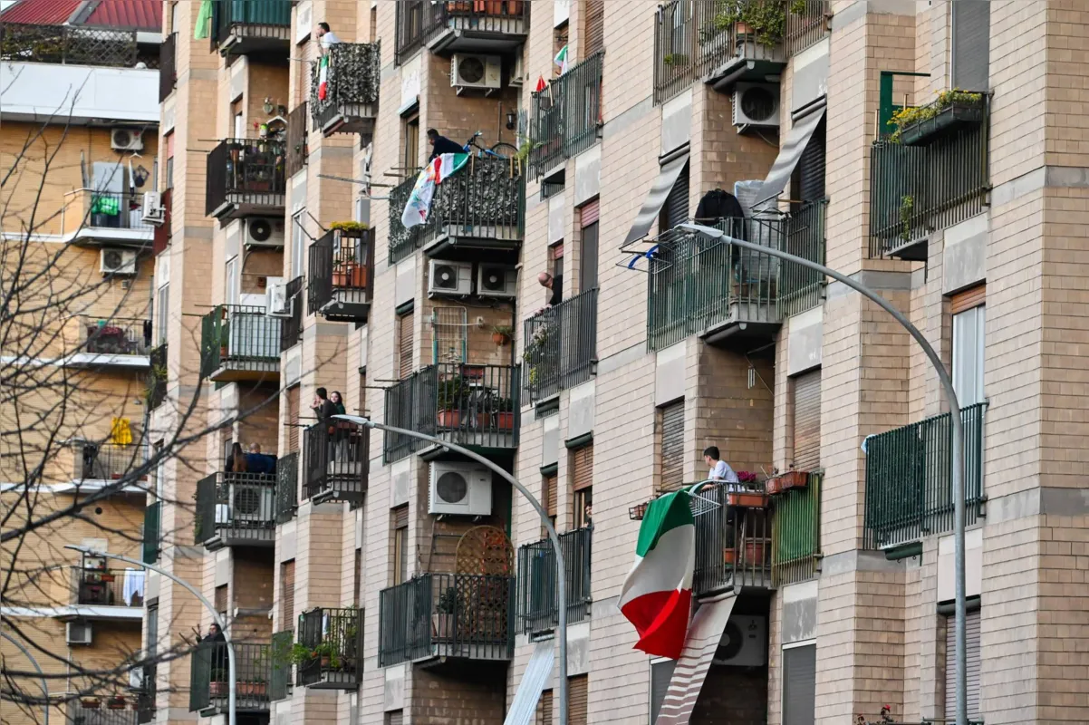 Impedidos de sair às ruas por causa da pandemia de coronavírus, italianos cantam e confraternizam nas janelas dos prédios  em várias cidades do país