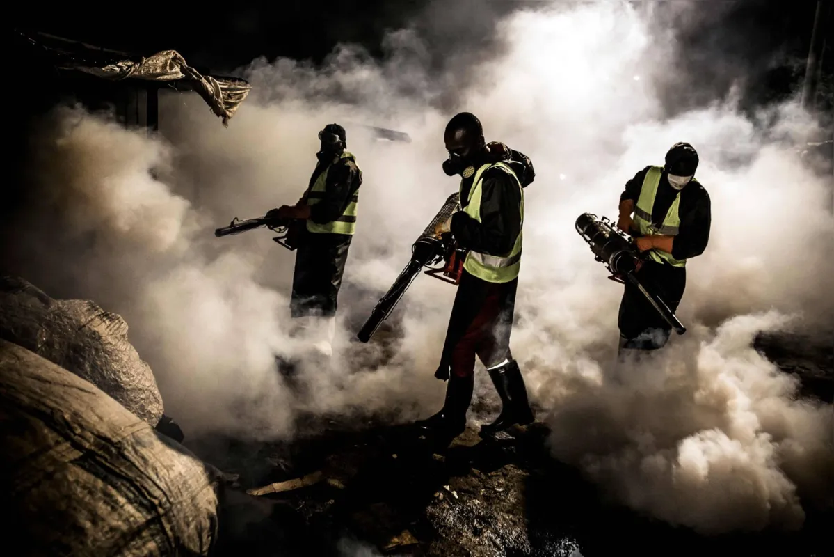 Trabalhadores vestem roupas de proteção para desinfecção das ruas de Nairobi, Quênia