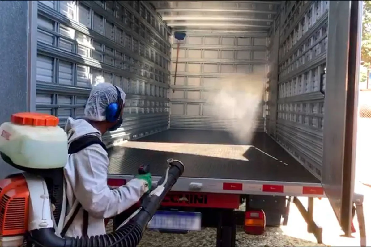 Trabalhador faz a limpeza do caminhão após entrega dos produtos