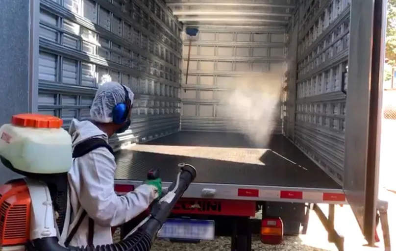 Trabalhador faz a limpeza do caminhão após entrega dos produtos