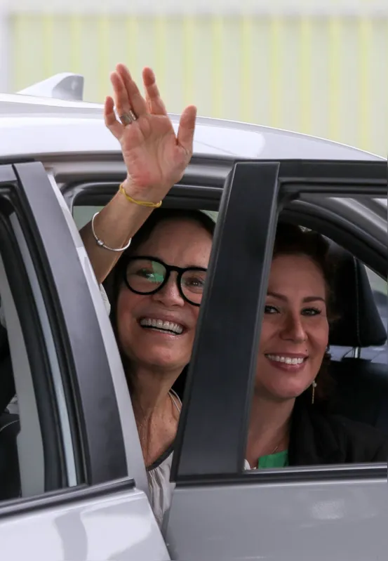 A atriz Regina Duarte, ao lado da deputada Carla Zambelli (PSL-SP), acena ao sair do Palácio da Alvorada: atriz diz que ganhou "presente" de Bolsonaro


