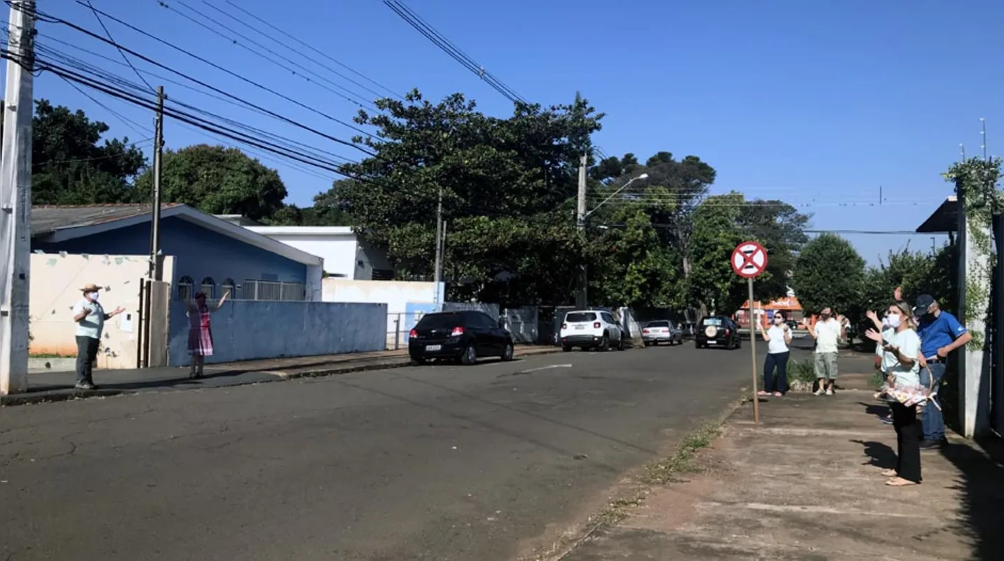 Participantes fazem oração do outro lado da rua para evitar aglomeração