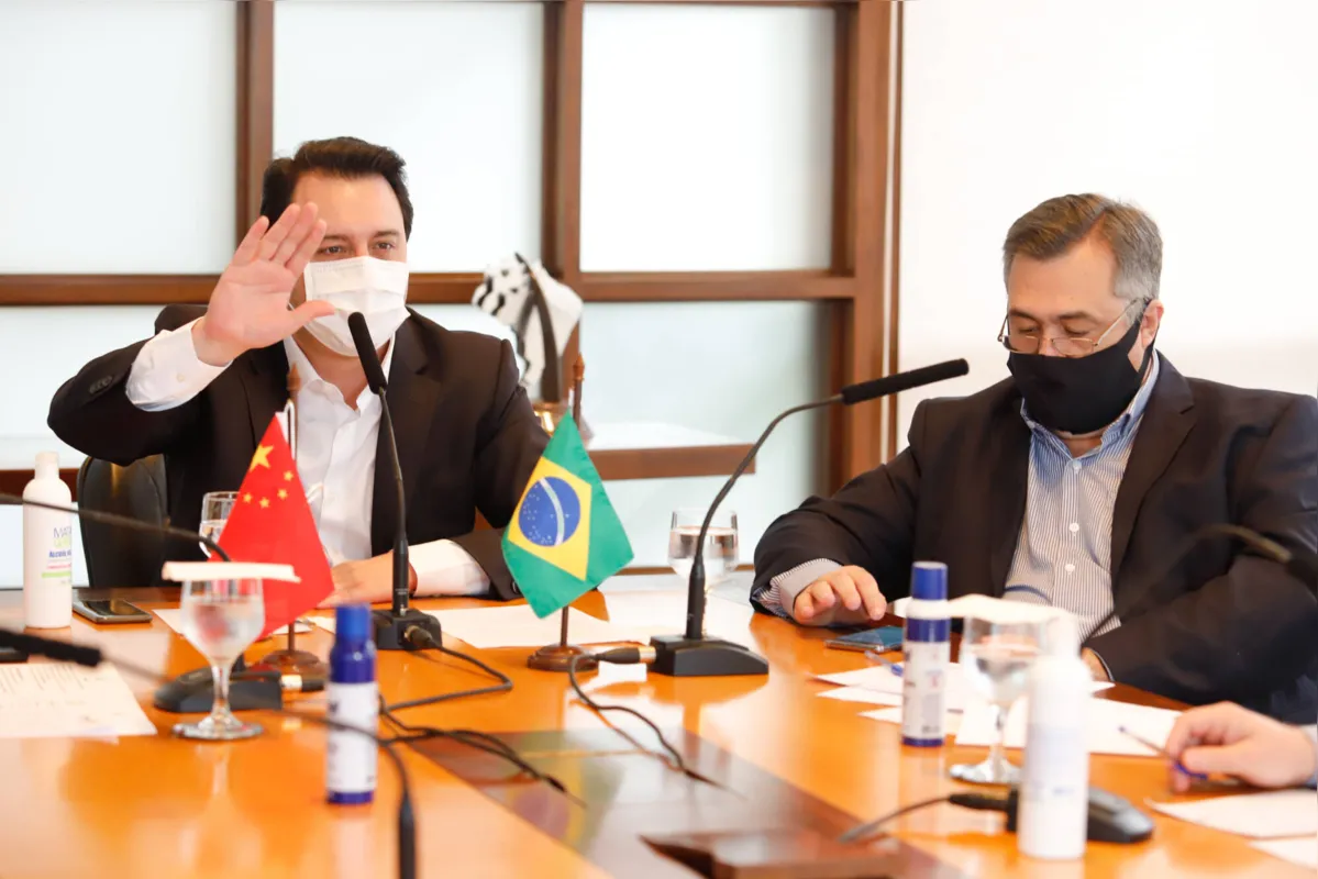 Ao lado do secretário de Saúde Beto Preto, o governador Ratinho Junior conversa com a comissão chinesa via videoconferência