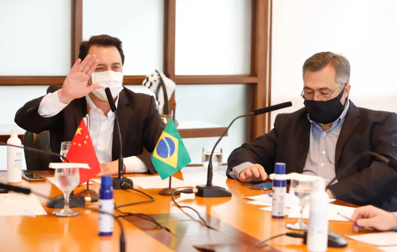 Ao lado do secretário de Saúde Beto Preto, o governador Ratinho Junior conversa com a comissão chinesa via videoconferência