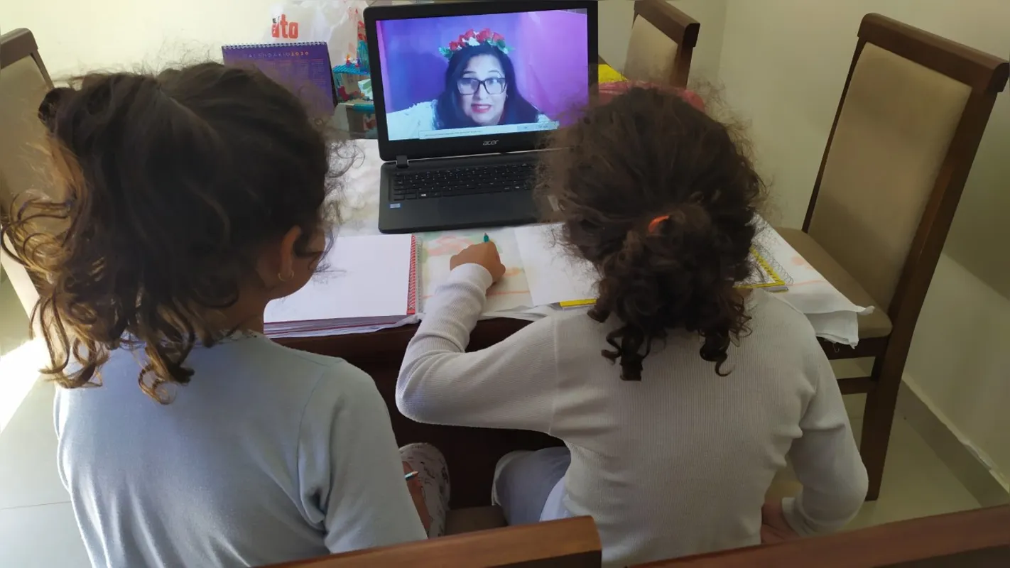 Alunas assistindo à aula remota da Escola Municipal Maestro Roberto Pereira Panico que aderiu  ao "Projeto Ciência e Cultura, Vamos Brincar?" transmitido aos sábados no YouTube