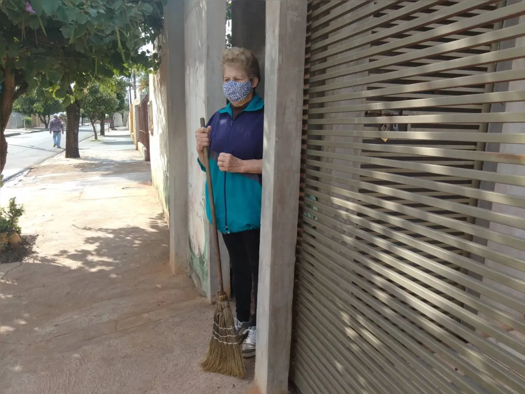 Zenir Carvalho usa máscara até para varrer a calçada