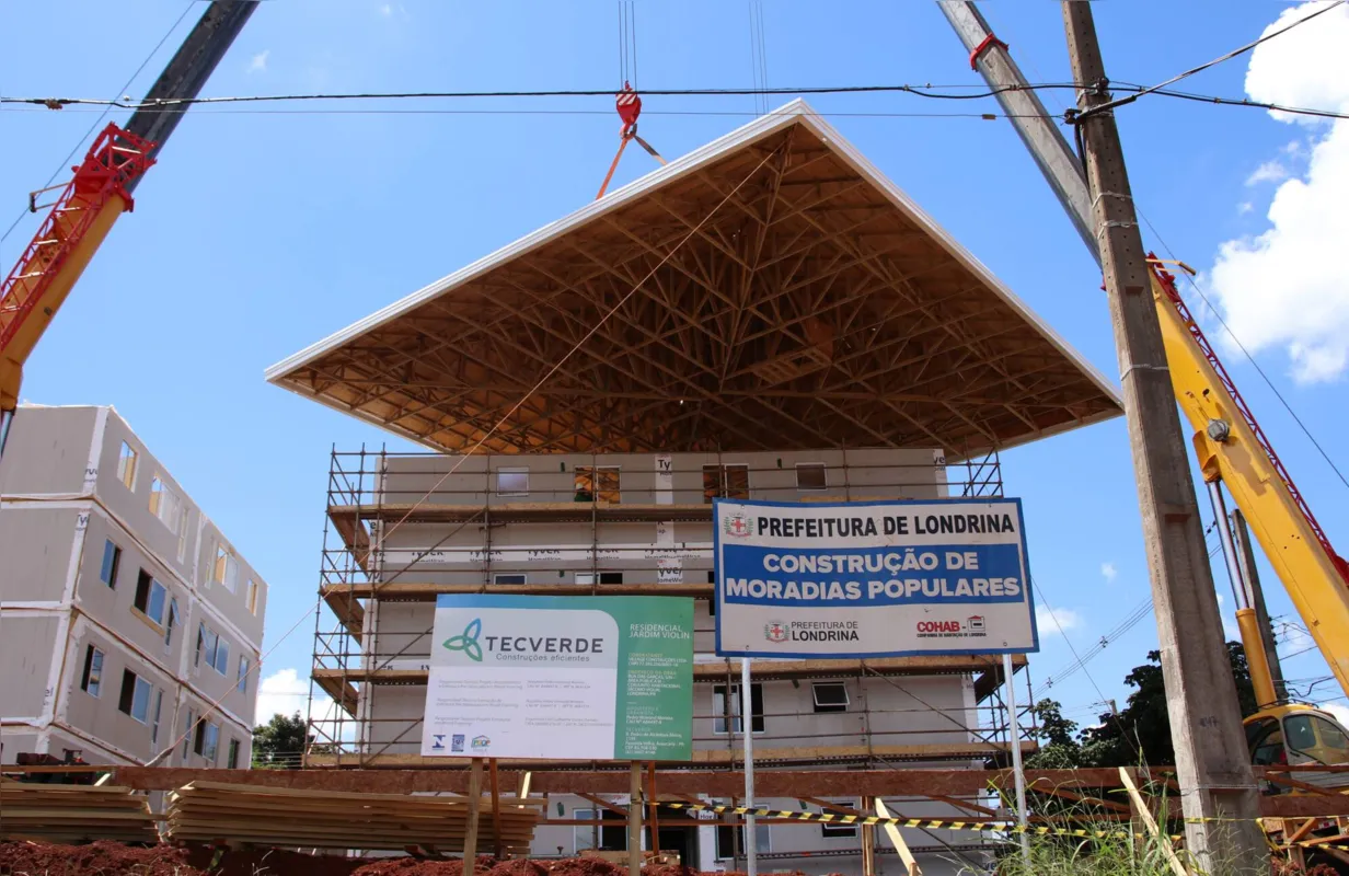 A colocação das coberturas dos prédios foi realizada por meio de dois guindastes de grande porte