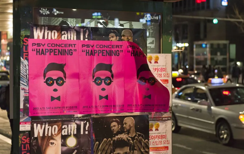 Cartaz de show do rapper sul-coreano Psy em rua de Seul em 2013: sua música "Gangnam Style" atingiu um bilhão de visualizações no YouTube e abriu as portas para o K-pop no mundo 