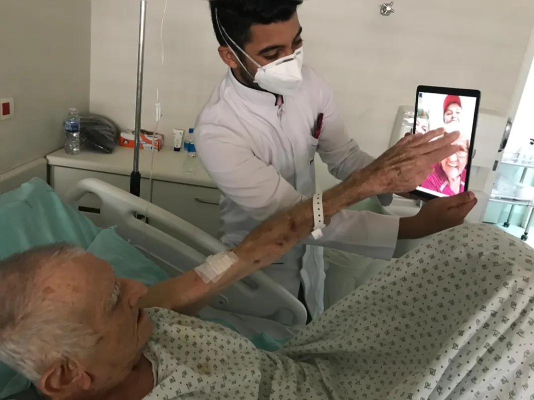 O paciente Pedro Marsola, 91, tem contato com a família, com a ajuda do estagiário de enfermagem, Alisson Santos: dia de videochamada 