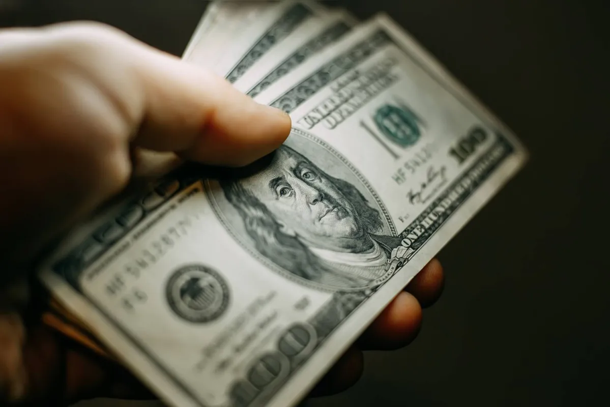 Man hand with a stack of hundred US dollars bills, close up
