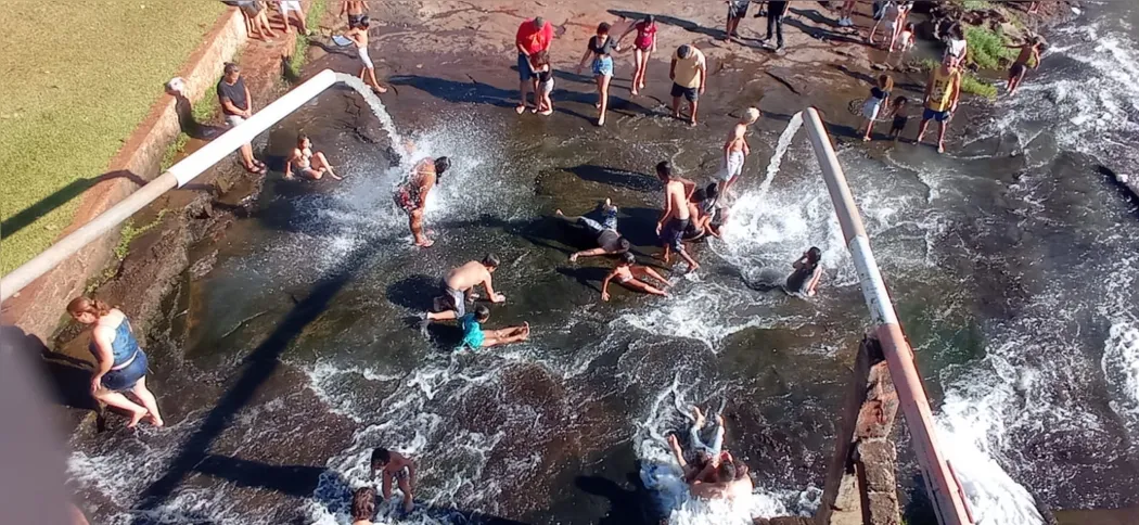 Os vertedouros da barragem do lago se transformam em cachoeira no miolo da cidade em dias de verão