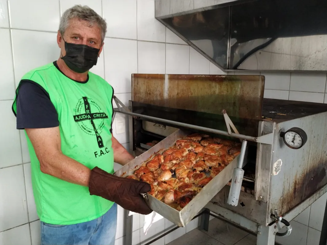 Adãode Pauli ajuda a preparar os 200 quilos de frango assado