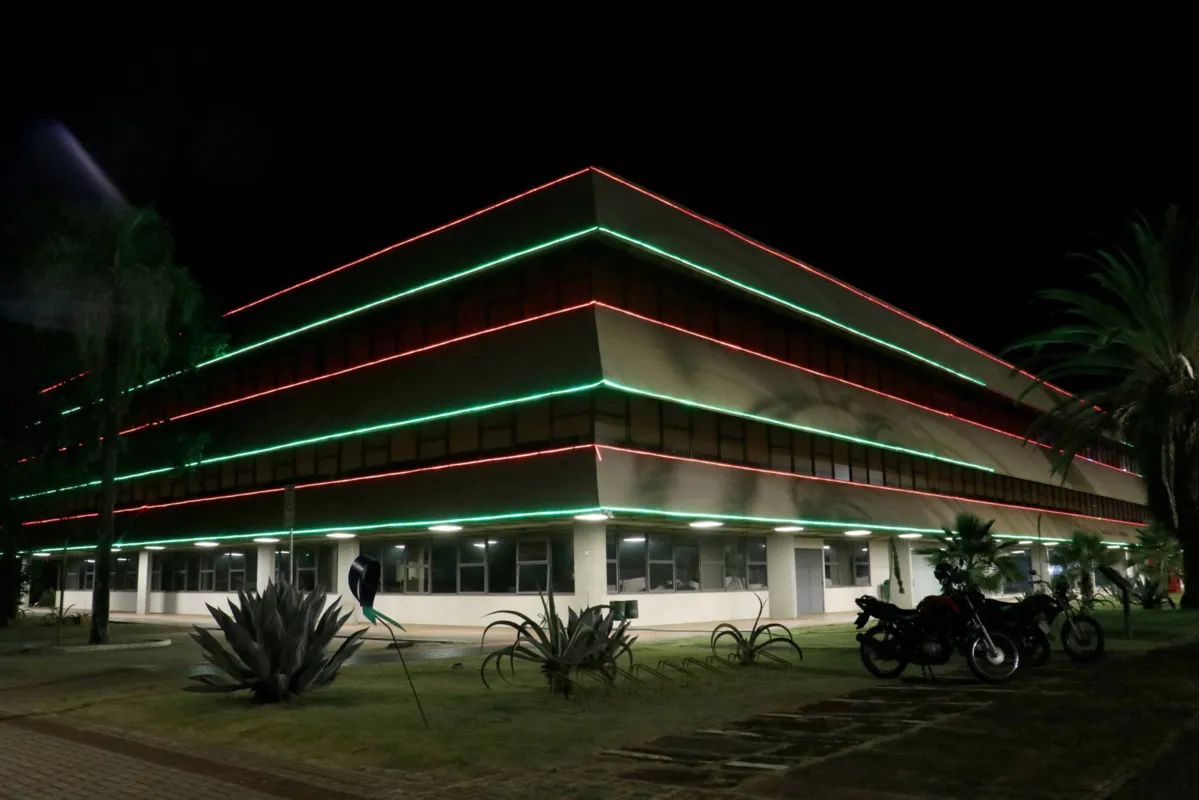 Prefeitura municipal decorada com luzes vermelhas e verdes, típicas do Natal 