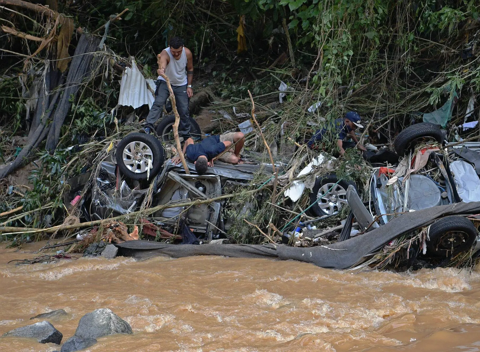 Pessoas tentam resgatar itens de carros tombados pelas enxurradas (Petrópolis/ 16-02-2022)