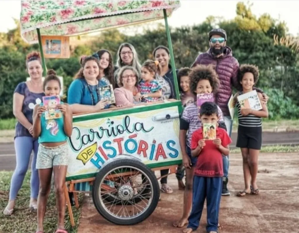 Leandro Palmerah 
 junto à carriola da contadora de histórias Dani Fioruci que fez trabalho itinerante e agora fica na biblioteca Preta