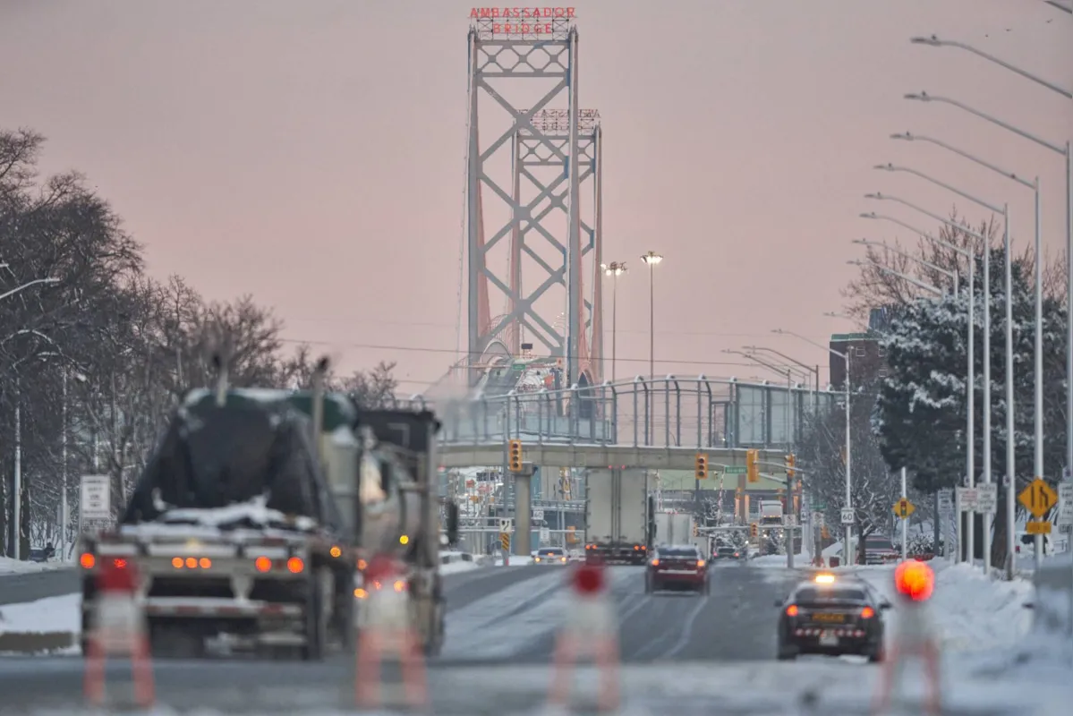 Trucks drive down the road towards the Ambassador Bridge border crossing in Windsor, Ontario on February 14, 2022. - The border crossing reopened to traffic last night-the bridge was closed for almost a week after Anti-Covid 19 Vaccine Mandate "Freedom Convoy" protestors blocked the road. (Photo by Geoff Robins / AFP)
