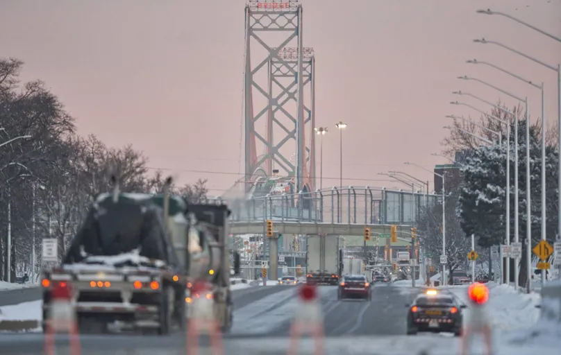 Trucks drive down the road towards the Ambassador Bridge border crossing in Windsor, Ontario on February 14, 2022. - The border crossing reopened to traffic last night-the bridge was closed for almost a week after Anti-Covid 19 Vaccine Mandate "Freedom Convoy" protestors blocked the road. (Photo by Geoff Robins / AFP)