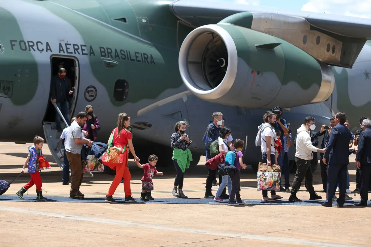 BRASÃLIA, DF, 10.03.2022 Â JAIR-BOLSONARO-DF - O presidente Jair Bolsonaro e a primeira-dama Michelle Bolsonaro recepcionam os brasileiros refugiados da guerra na UcrÃ¢nia, que foram resgatados em uma operaÃ§Ã£o da forÃ§a aÃ©rea. Pessoas de outras nacionalidades e animais domÃ©sticos tambÃ©m vieram no aviÃ£o cargueiro KC-390, da FAB. Na base aÃ©rea de BrasÃ­lia. (Foto: Pedro Ladeira/Folhapress)