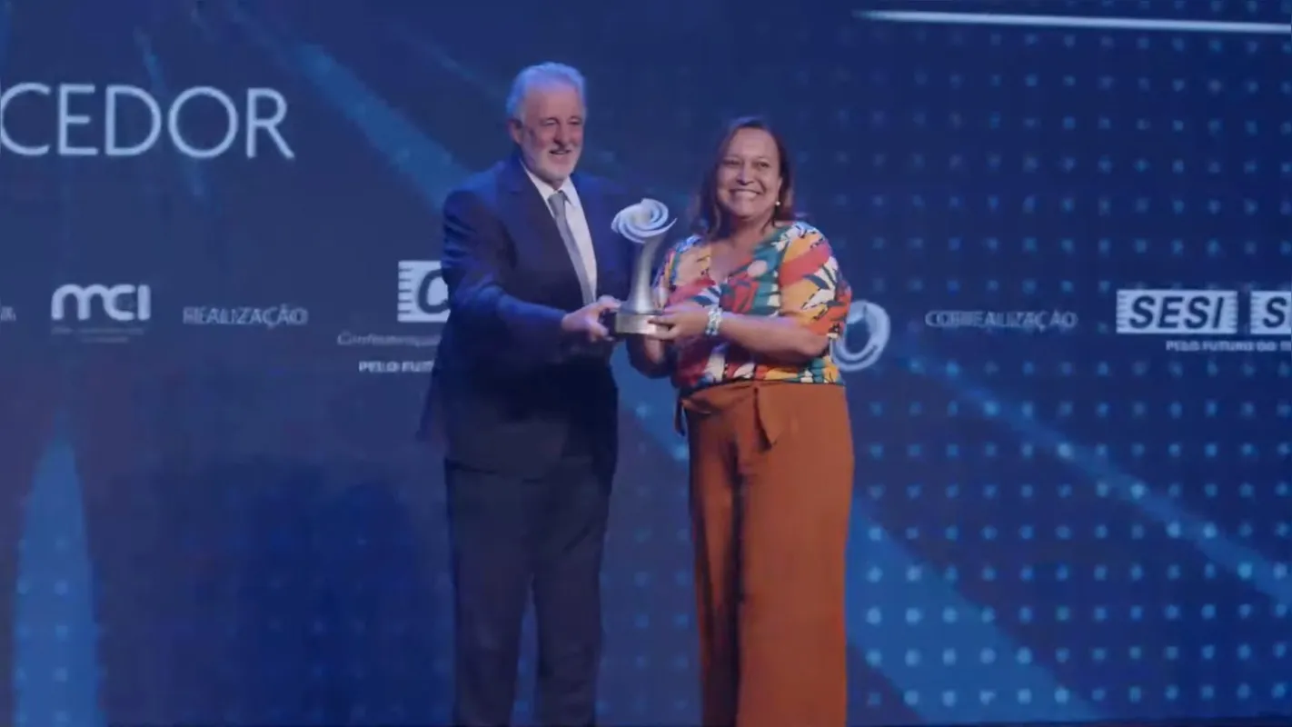 Angélica Cristina Moreira, presidente do SRI do Norte Pioneiro, recebe o prêmio do presidente do Sebrae, Carlos Melles