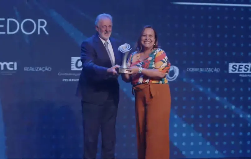 Angélica Cristina Moreira, presidente do SRI do Norte Pioneiro, recebe o prêmio do presidente do Sebrae, Carlos Melles