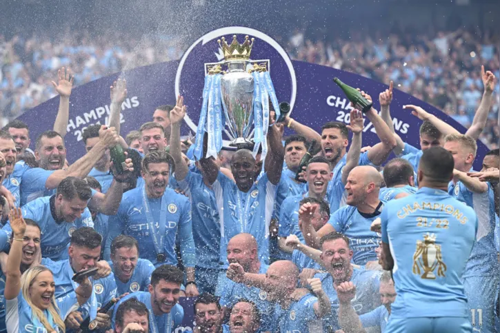 Manchester City's Brazilian midfielder Fernandinho lifts the Premier League trophy as City players celebrate on the pitch after the English Premier League football match between Manchester City and Aston Villa at the Etihad Stadium in Manchester, north west England, on May 22, 2022. - Manchester City won the Premier League for the fourth time in five seasons after a pulsating title race reached a dramatic conclusion as the champions staged an incredible comeback from two goals down to beat Aston Villa 3-2 on Sunday. (Photo by Oli SCARFF / AFP) / RESTRICTED TO EDITORIAL USE. No use with unauthorized audio, video, data, fixture lists, club/league logos or 'live' services. Online in-match use limited to 120 images. An additional 40 images may be used in extra time. No video emulation. Social media in-match use limited to 120 images. An additional 40 images may be used in extra time. No use in betting publications, games or single club/league/player publications. /