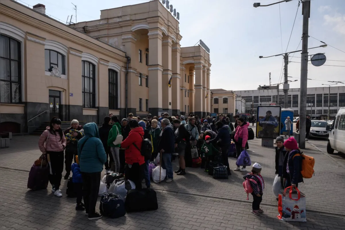 Internally displaced people prepare to board an evacuation train departing for Lviv, the day after arriving as part of a humanitarian convoy from the besieged city of Mariupol, at a railway station in the southern city of Zaporizhzhia on April 22, 2022. (Photo by Ed JONES / AFP)