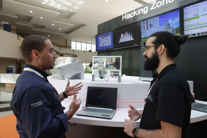 Jorny Lima, da EDF Norte Fluminense, simula ataque hacker com supervisão de Matheus Tourinho, técnico em P&D da TI Safe, durante a CLASS 2022