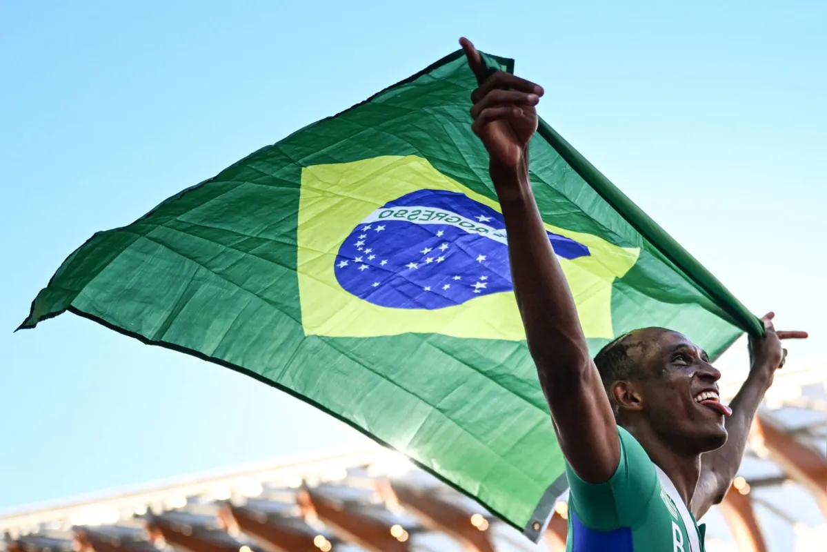 Brazil's Alison Dos Santos celebrates with a Brazilian flag after winning the men's 400m hurdles final during the World Athletics Championships at Hayward Field in Eugene, Oregon on July 19, 2022. (Photo by Jewel SAMAD / AFP)
