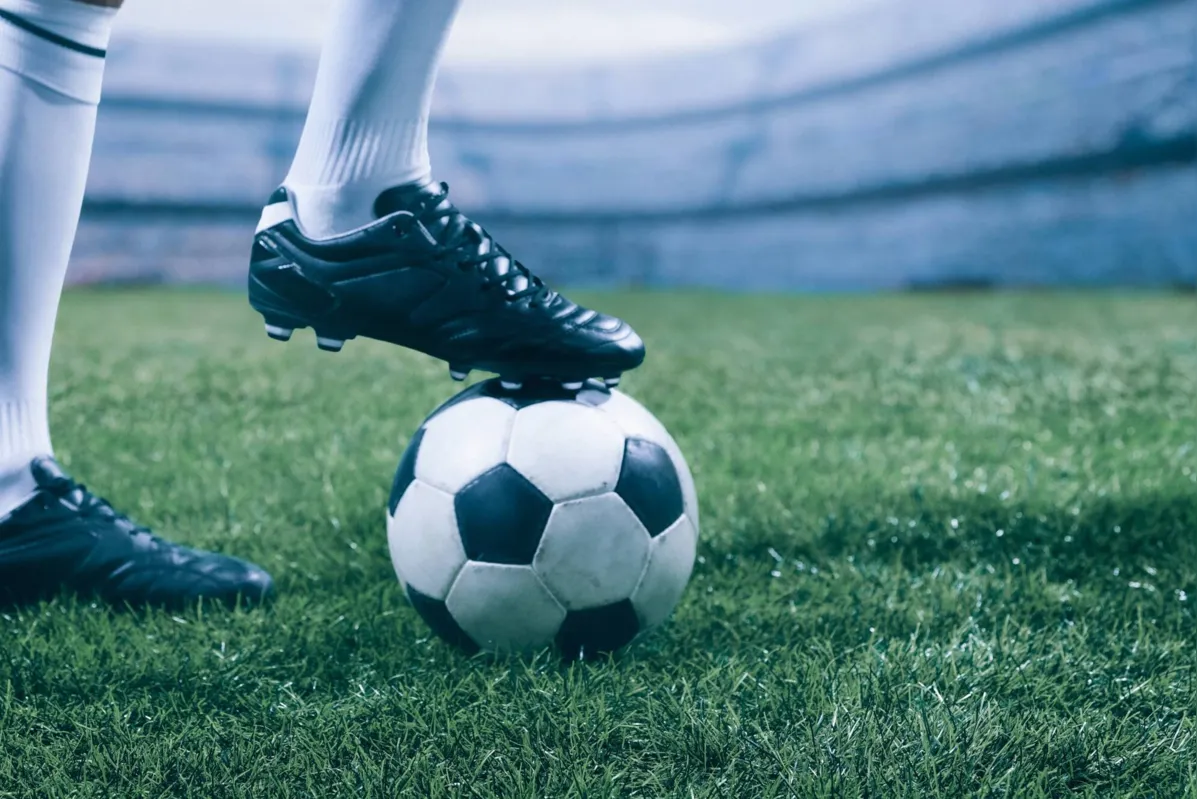 Soccer player in action on a professional arena full of spectators. Sport stadium made in 3D
