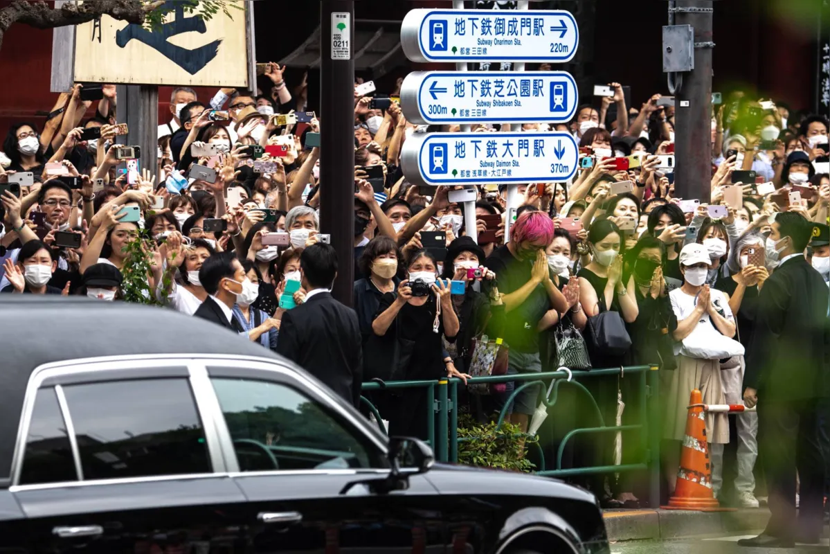 Philip Fong/AFP 

No trajeto nas ruas, várias pessoas rezaram e exibiram fotografias de Abe