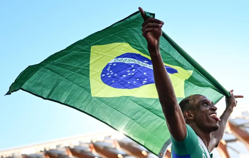Brazil's Alison Dos Santos celebrates with a Brazilian flag after winning the men's 400m hurdles final during the World Athletics Championships at Hayward Field in Eugene, Oregon on July 19, 2022. (Photo by Jewel SAMAD / AFP)