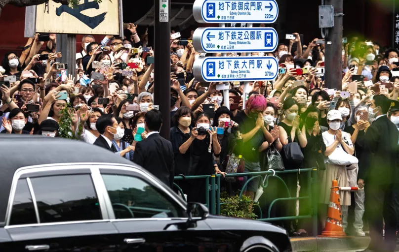 Philip Fong/AFP 

No trajeto nas ruas, várias pessoas rezaram e exibiram fotografias de Abe