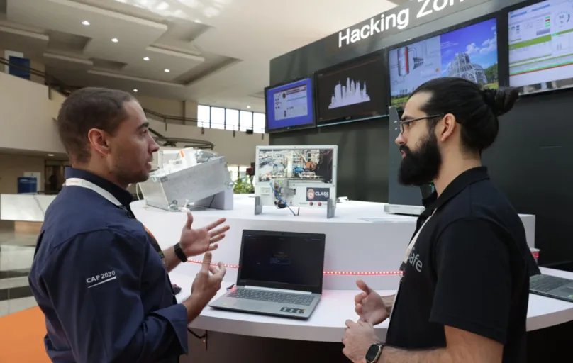 Jorny Lima, da EDF Norte Fluminense, simula ataque hacker com supervisão de Matheus Tourinho, técnico em P&D da TI Safe, durante a CLASS 2022