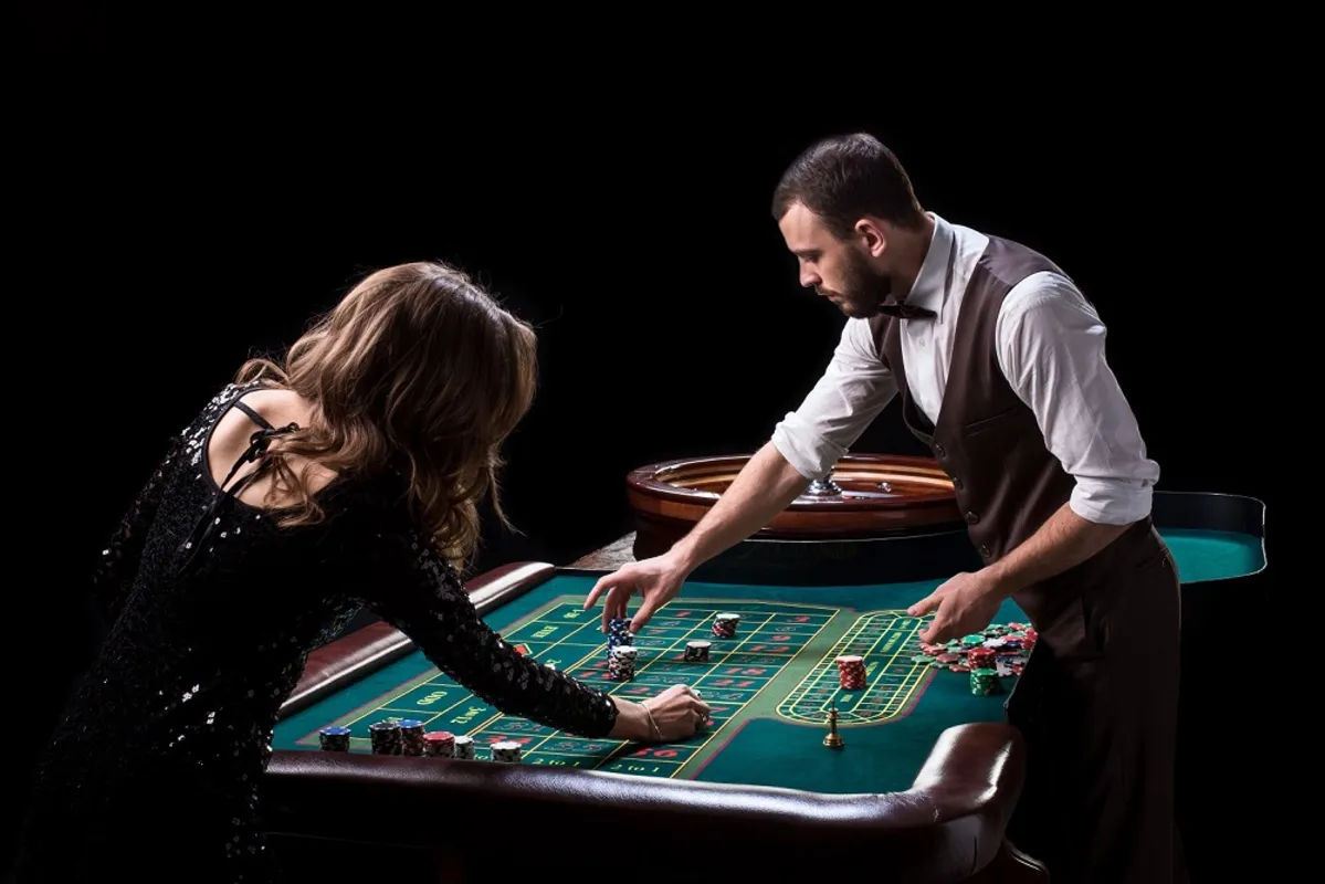 Croupier and woman player at a table in a casino. Picture of a classic casino roulette wheel. Gambling. Casino. Roulette. Poker