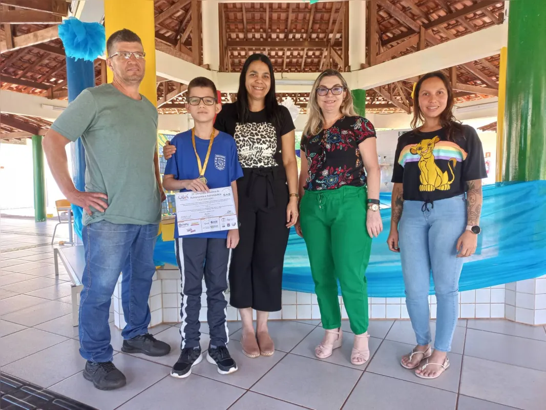 Arthur ao lado dos pais, Adelson e Andrea Pereira, da professora, Vera Lúcia, e da diretora, Anna Amélia: "aluno muito organizado"
