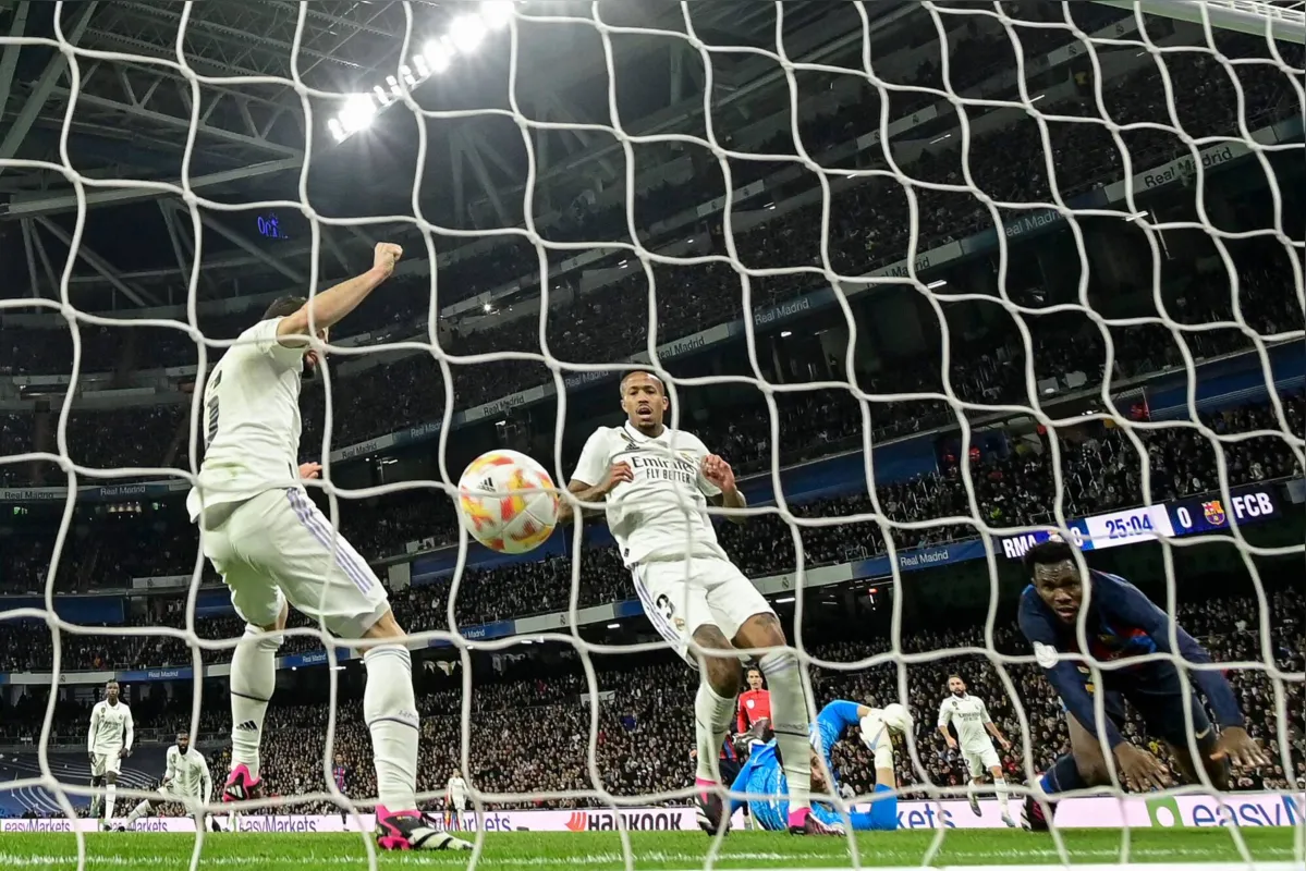 Real Madrid's Brazilian defender Eder Militao (C) reacts after scoring an own-goal next to Barcelona's Ivorian midfielder Franck Kessie (R) during the Copa del Rey (King's Cup) semi final first leg football match between Real Madrid CF and FC Barcelona at the Santiago Bernabeu stadium in Madrid on March 2, 2023. (Photo by JAVIER SORIANO / AFP)