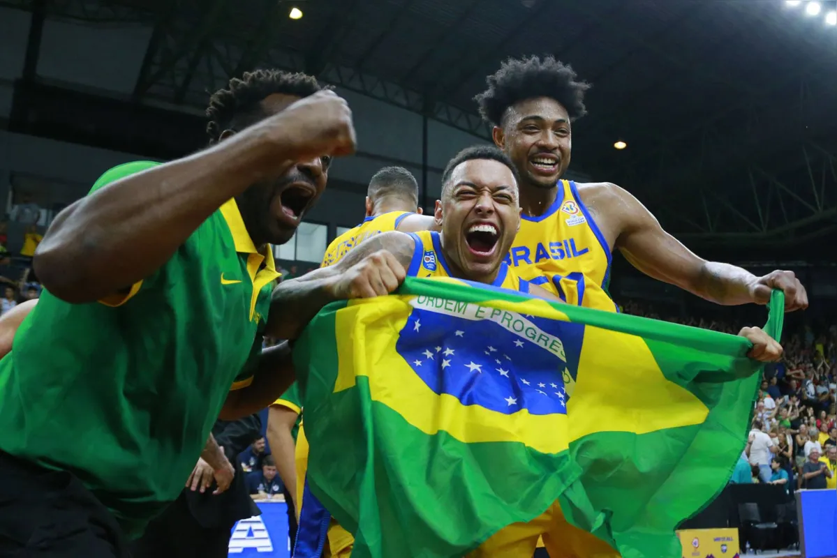 Brazil's Yago dos Santos and Bruno Caboclo celebrate after defeating the USA at the end of their FIBA Basketball World Cup 2023 Americas qualifiers match at the Arnão Multisport Gym in Santa Cruz do Sul, South of Brazil, on February 26, 2023. (Photo by SILVIO AVILA / AFP)