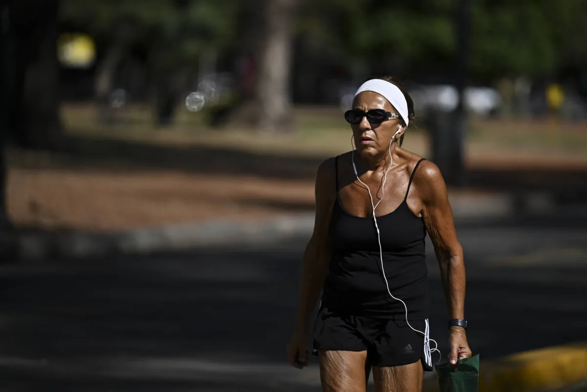 Mulher caminha no Parque Rosedal em Buenos Aires: capital argentina registra calor histórico