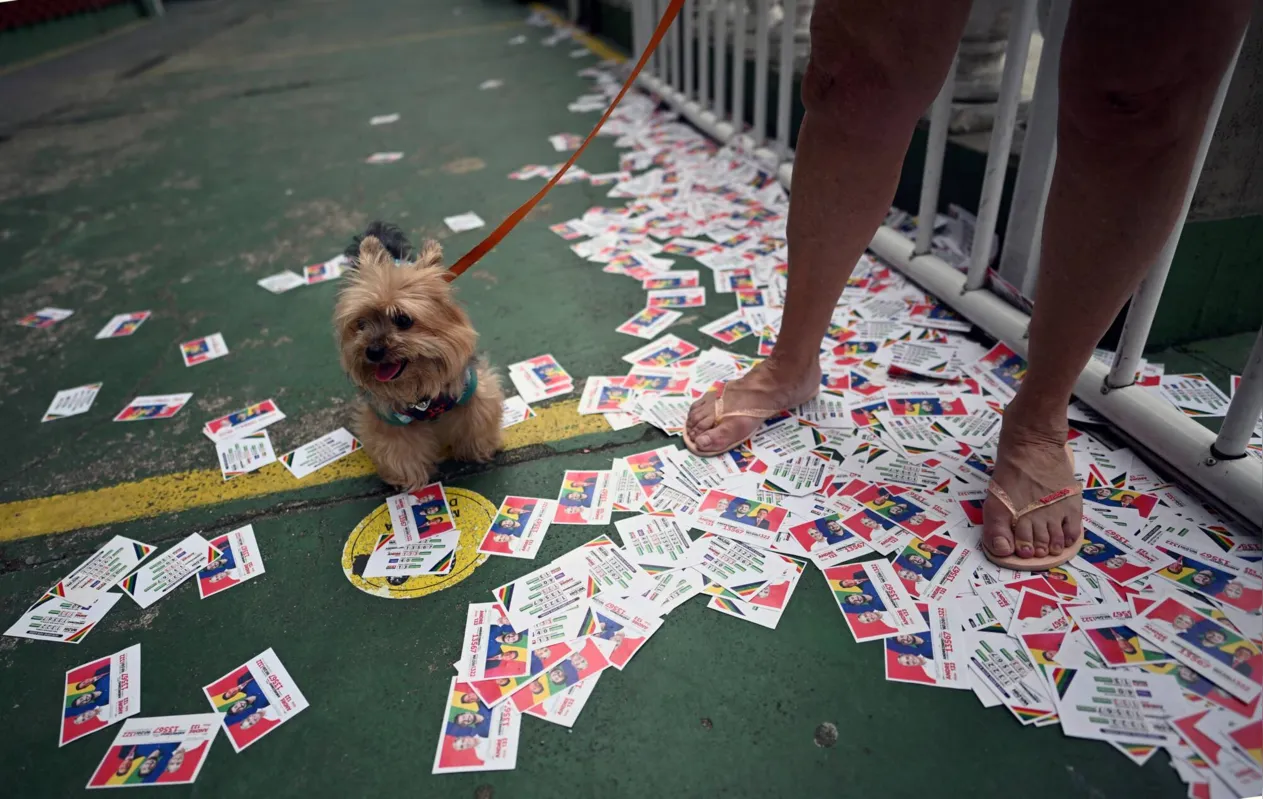 A woman and her dog during the legislative and presidential election, in Rio de Janeiro, Brazil, on October 2, 2022. - Voting began early Sunday in South America's biggest economy, plagued by gaping inequalities and violence, where voters ar expected to choose between far-right incumbent Jair Bolsonaro and leftist front-runner Luiz Inacio Lula da Silva, any of which must garner 50 percent of valid votes, plus one, to win in the first round. (Photo by CARL DE SOUZA / AFP)