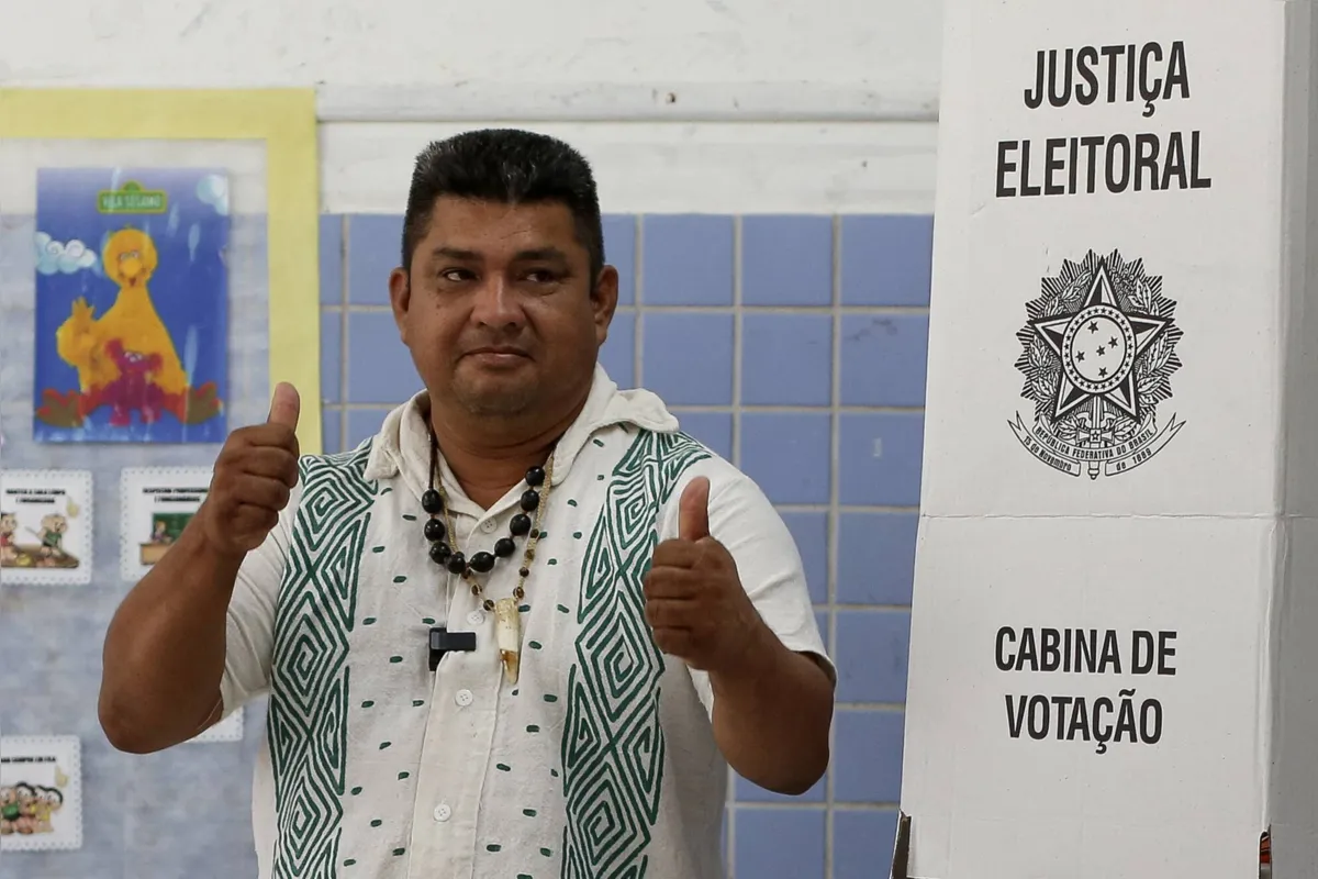 Indigenous Kambeba Raimundo Cruz da Silva gives his thumbs up after casting his vote during the legislative and presidential election, in the Tr?s Unidos Community, in the Negro river, Amazonas state, Brazil, on October 2, 2022. - Voting began early Sunday in South America's biggest economy, plagued by gaping inequalities and violence, where voters ar expected to choose between far-right incumbent Jair Bolsonaro and leftist front-runner Luiz Inacio Lula da Silva, any of which must garner 50 percent of valid votes, plus one, to win in the first round. (Photo by Michael DANTAS / AFP)