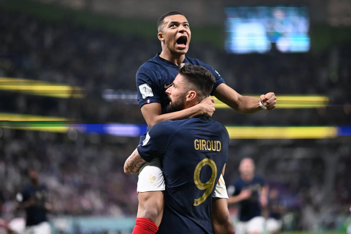 France's forward #09 Olivier Giroud celebrates with France's forward #10 Kylian Mbappe (top) after scoring his team's first goal during the Qatar 2022 World Cup round of 16 football match between France and Poland at the Al-Thumama Stadium in Doha on December 4, 2022. (Photo by Kirill KUDRYAVTSEV / AFP)