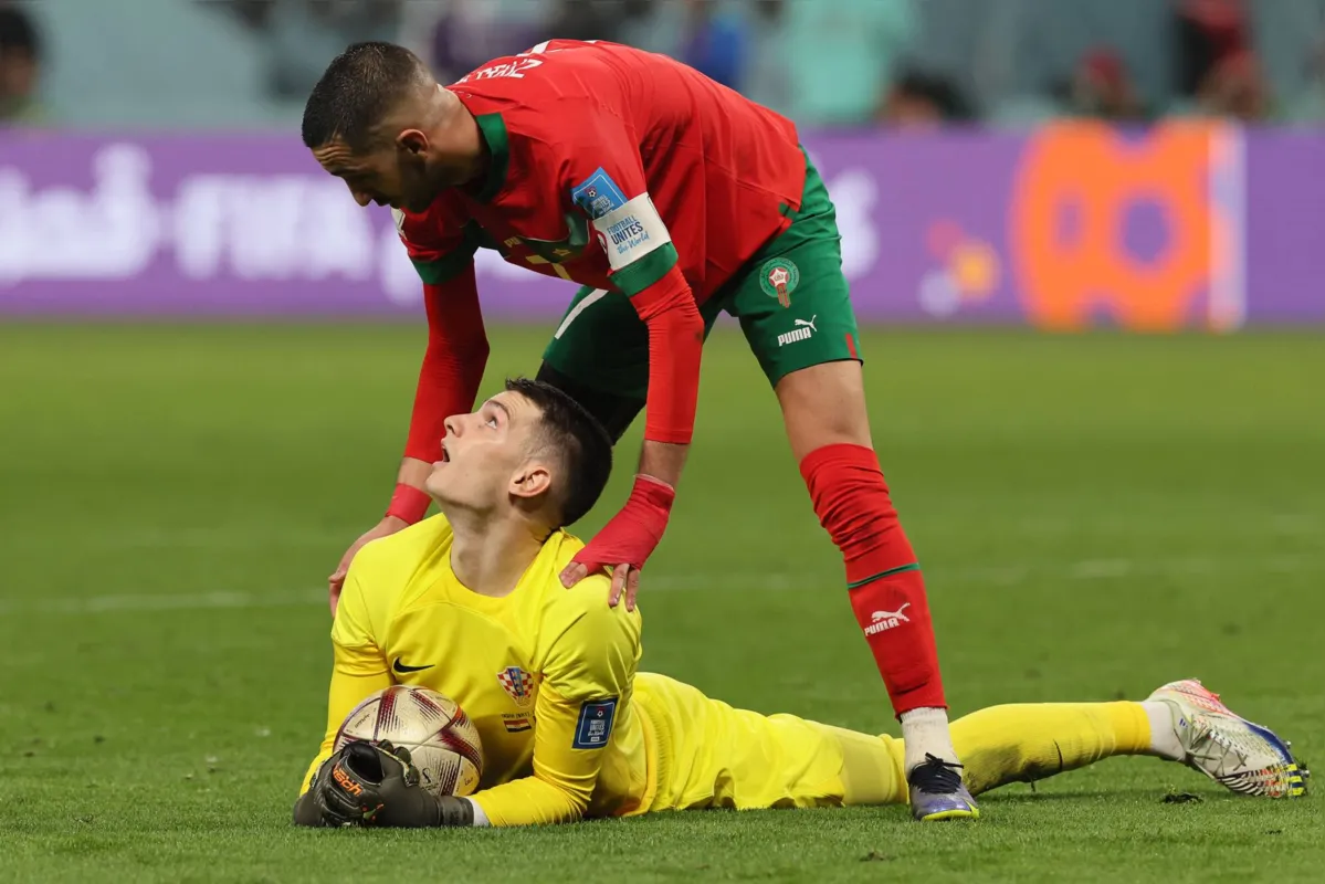 Morocco's midfielder #07 Hakim Ziyech and Croatia's goalkeeper #01 Dominik Livakovic interact during the Qatar 2022 World Cup third place play-off football match between Croatia and Morocco at Khalifa International Stadium in Doha on December 17, 2022. (Photo by KARIM JAAFAR / AFP)