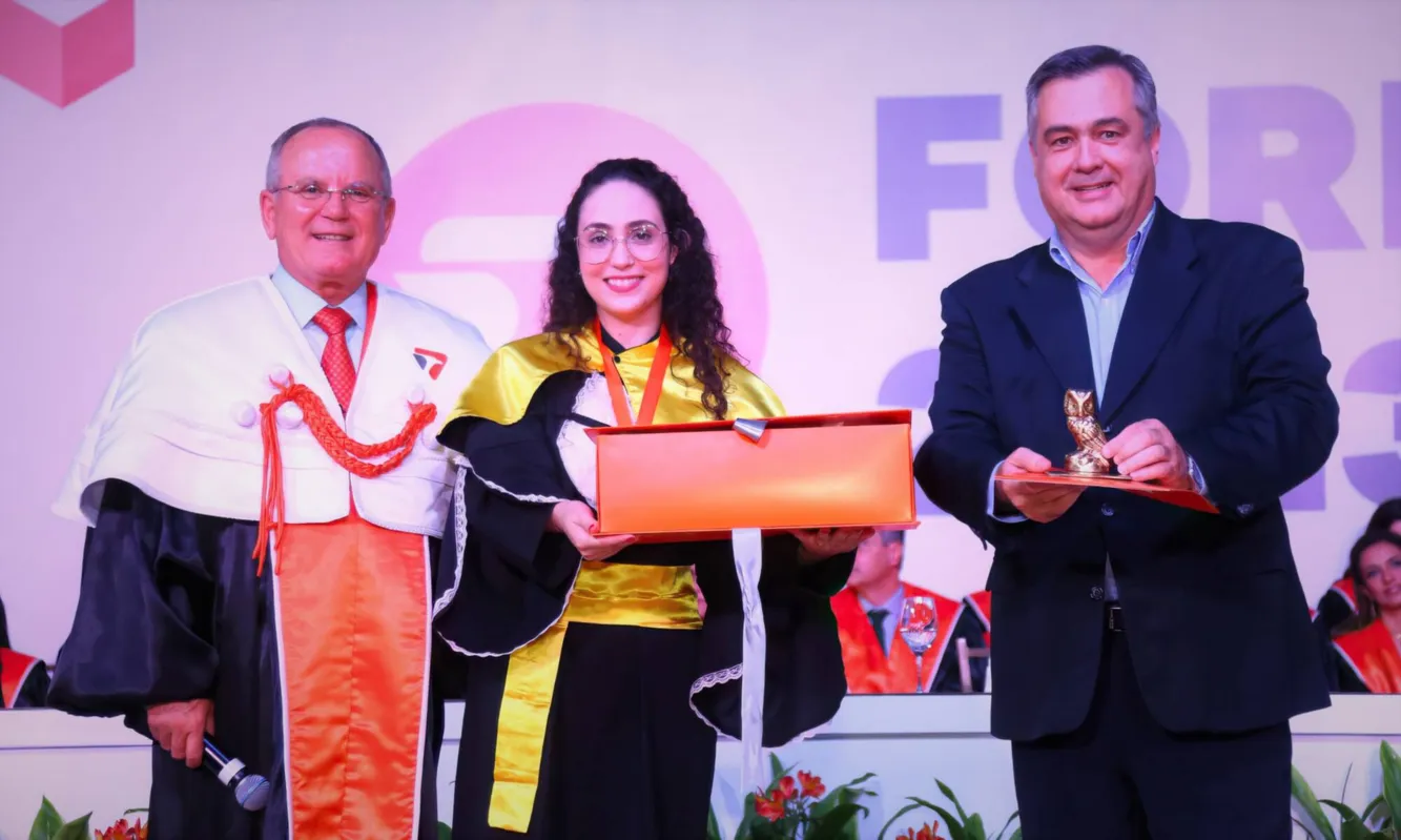 Reitor Eleazar e o deputado federal Beto Preto, paraninfo geral, entregam troféu de Láurea Acadêmica para Mylena Pascoal Medeiros, de Farmácia, com média geral 98,33