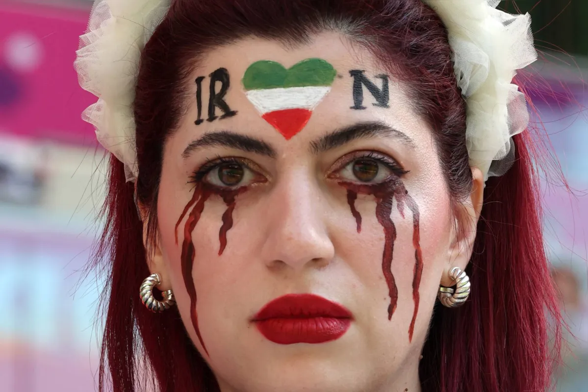 Torcedora iraniana maquiada com uma lágrima no rosto; ou seria a representação do sangue de tantas que foram mortas?