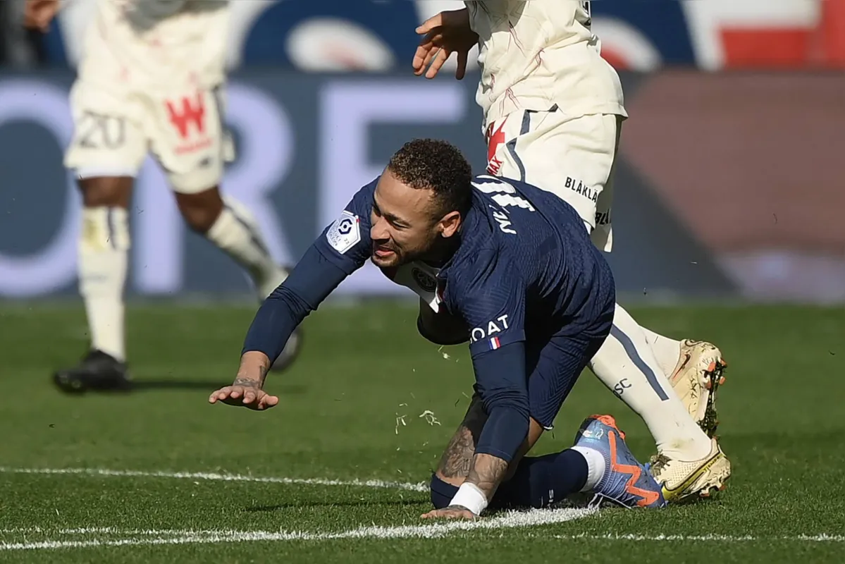 (FILES) In this file photo taken on February 19, 2023 Paris Saint-Germain's Brazilian forward Neymar falls, injured after a contact with Lille's French midfielder Benjamin Andre during the French L1 football match between Paris Saint-Germain (PSG) and Lille LOSC at The Parc des Princes Stadium in Paris. - Paris Saint-Germain striker Neymar will undergo ankle surgery "in the next few days" and will be out of action for three to four months, the club announced on March 6, 2023. (Photo by FRANCK FIFE / AFP)